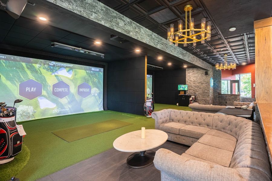 A golf simulator bay at Tees & Taps Orchard Park